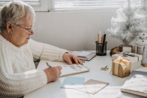 A senior woman writing a list of her goals