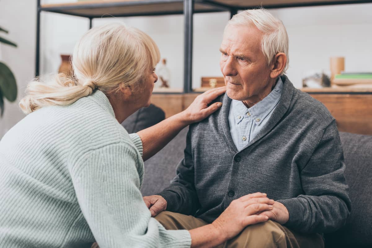 A senior woman talking to a confused looking senior man