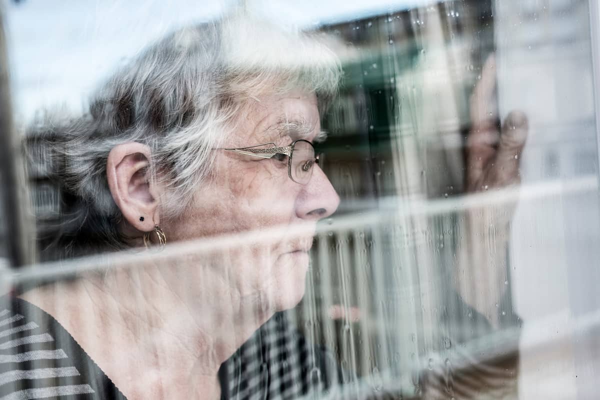 A senior woman looking out a window