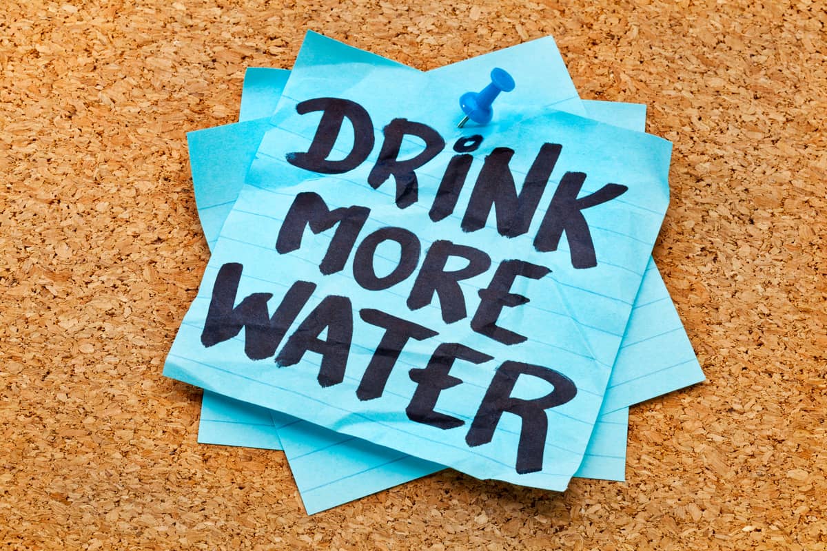 A post-it not that says "Drink more water"