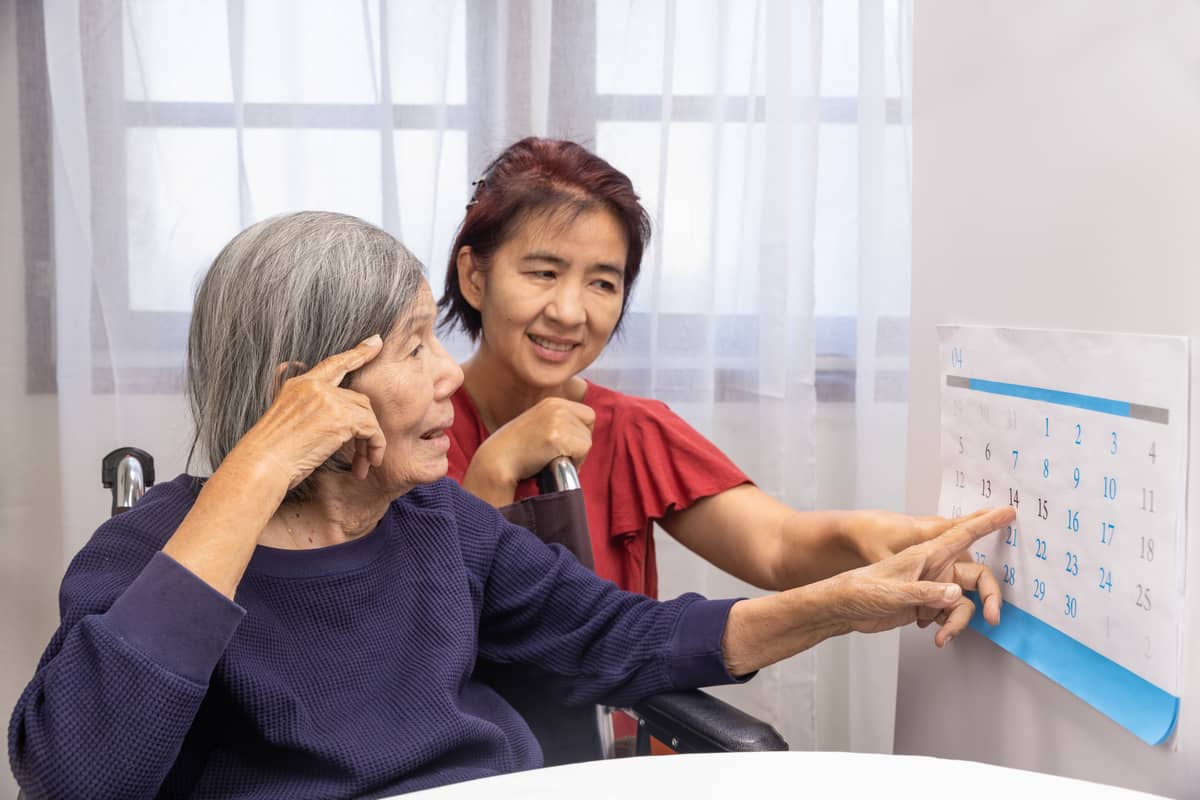 A woman showing a senior woman a calendar