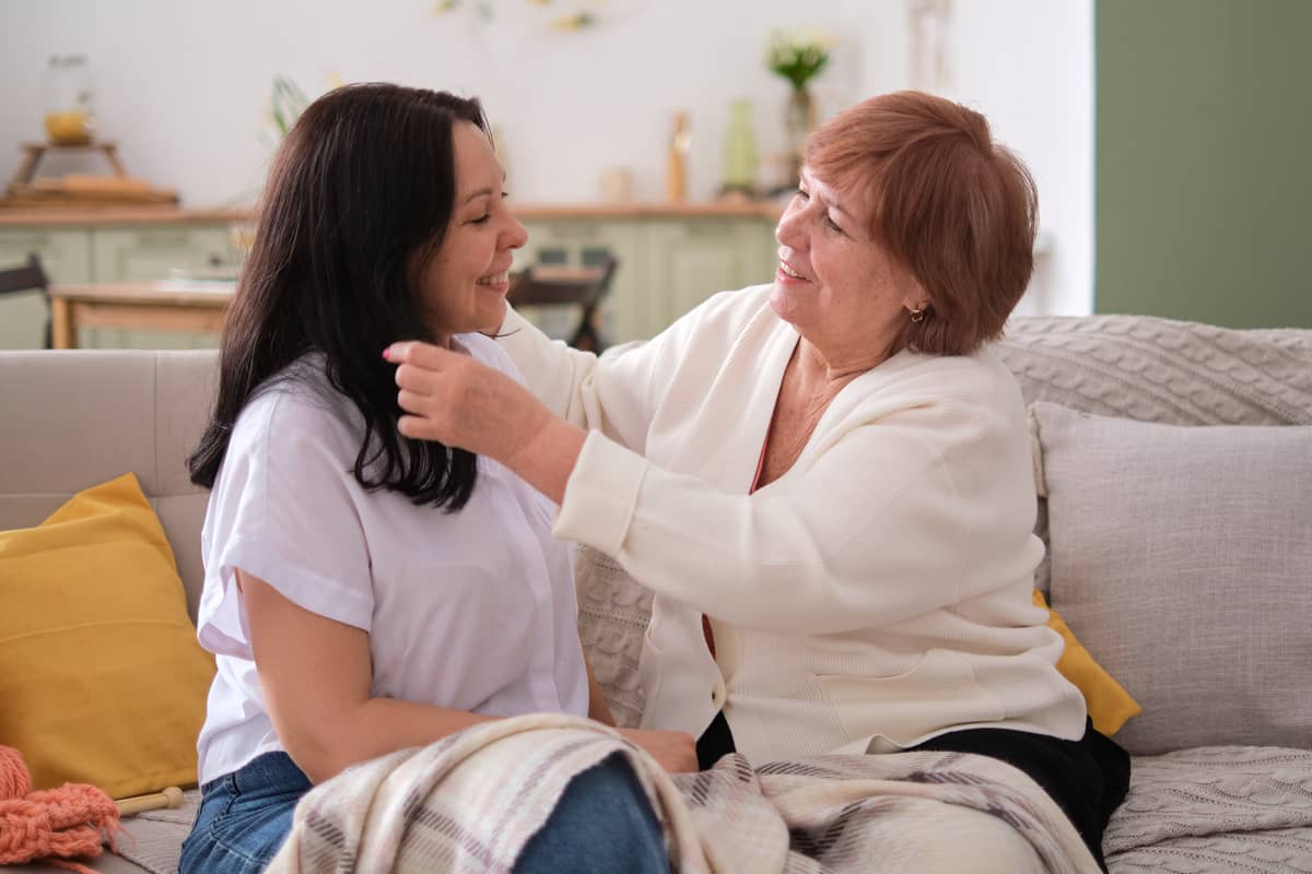 A senior woman on the couch with another younger woman