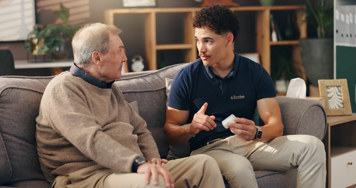 A man explaining a medication to a senior