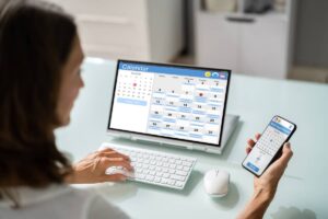 An appointment liaison setting appointments with a calendar open on phone and laptop
