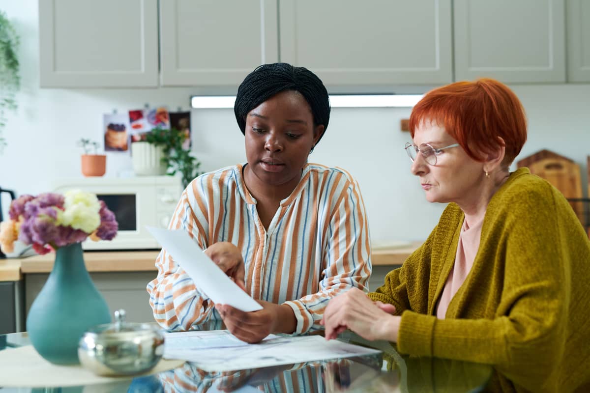 A woman helping a senior woman with paperwork