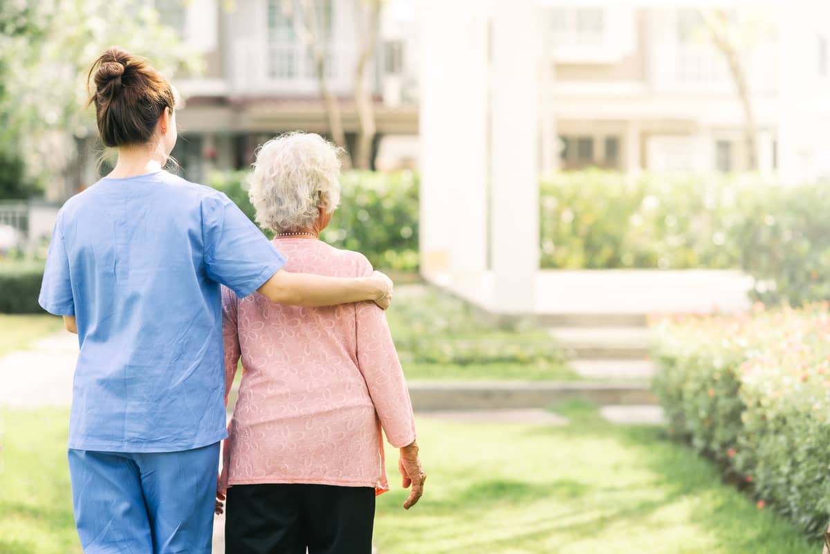 A caregiver walking with a senior woman