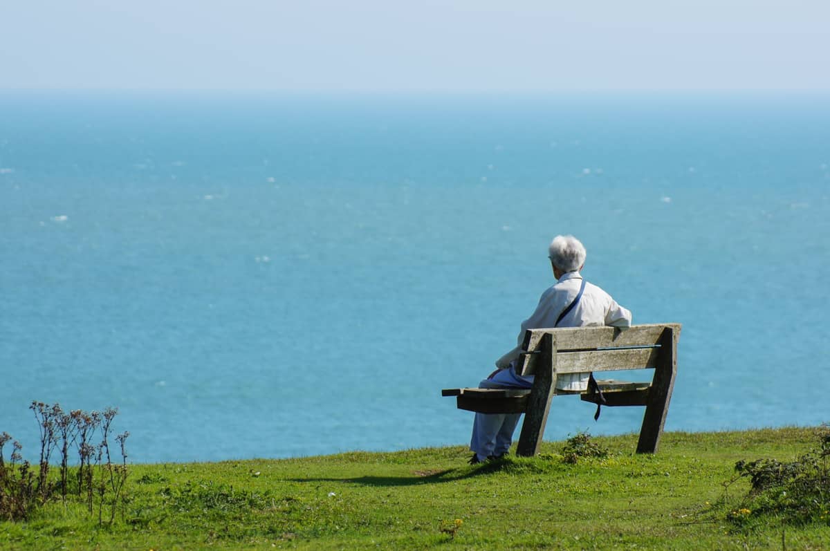 A senior man sitting by the sea