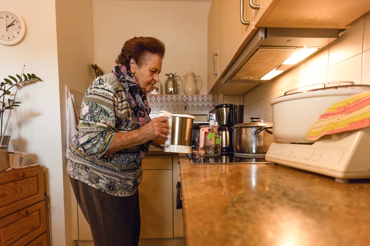 A senior woman making coffee