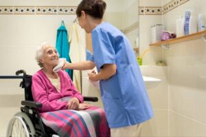 A home caregiver helping a senior woman with grooming