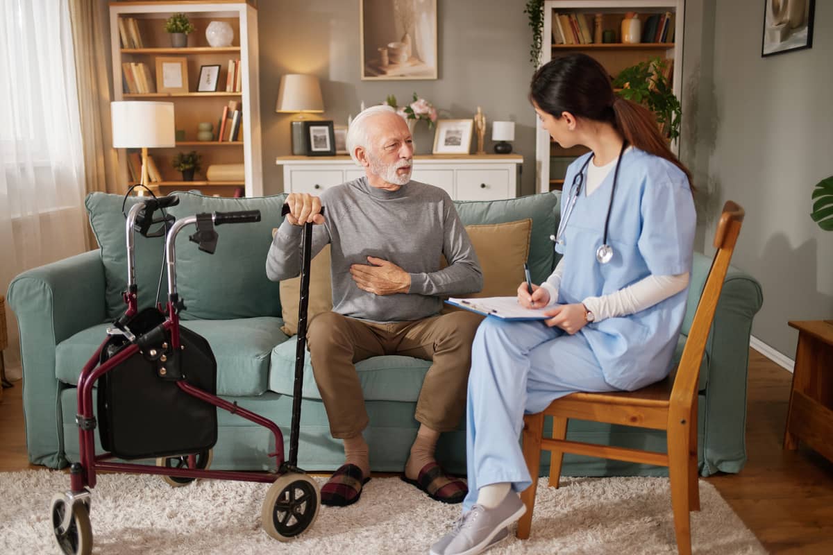 A home care provider talking a senior man